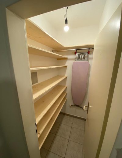 Schmaler Hauswirtschaftsraum mit Holzregalen