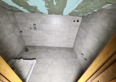 Badezimmer mit hellgrauen Wand- und Bodenfliesen